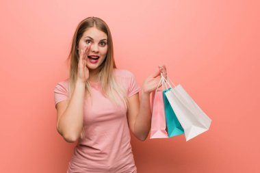 Genç, güzel, Rus bir kız ön tarafa mutlu bir şey bağırıyor. Elinde bir alışveriş çantası var..