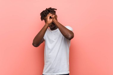 Genç Afrikalı siyahi adam uzaklara bakıyor ve onu alnında tutuyor..