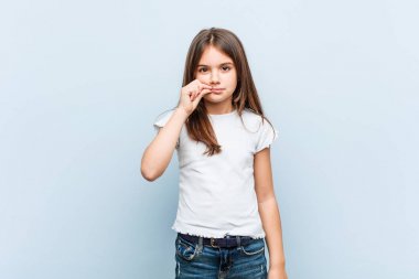 Dudaklarında bir sır tutan parmakları ile sevimli kız.