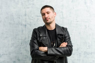 Genç rockçı mutsuz, iğneleyici ifadesiyle kameraya bakıyor..