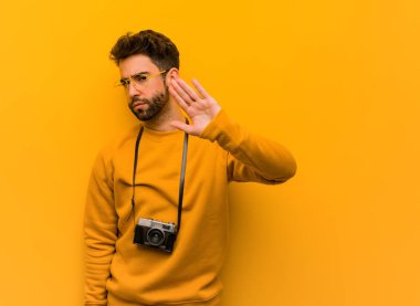 Genç fotoğrafçı elini öne koyuyor.