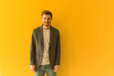 Genç kızıl saçlı iş adamı. Neşeli, büyük bir gülümsemesi olan.