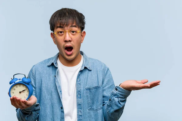 Jovem Chinês Segurando Despertador Segurando Algo Palma Mão — Fotografia de Stock