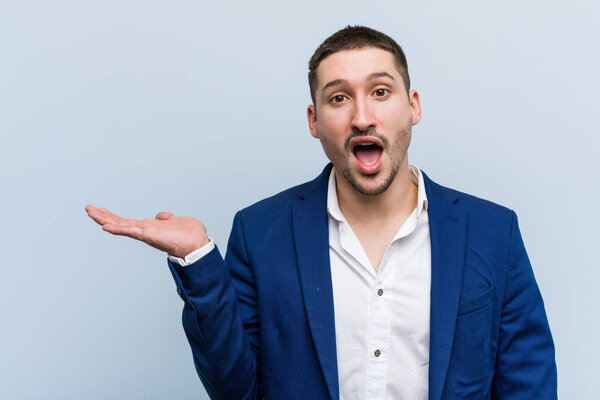 Молодой кавказский бизнесмен впечатлен тем, что держит на ладони пространство для копирования
.