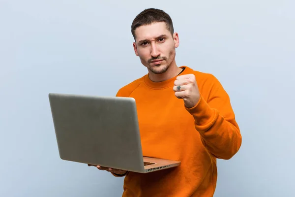 Jovem Caucasiano Segurando Laptop Mostrando Punho Para Câmera Expressão Facial — Fotografia de Stock