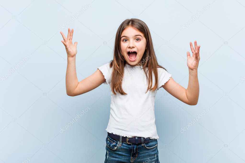 Cute girl receiving a pleasant surprise, excited and raising hands.