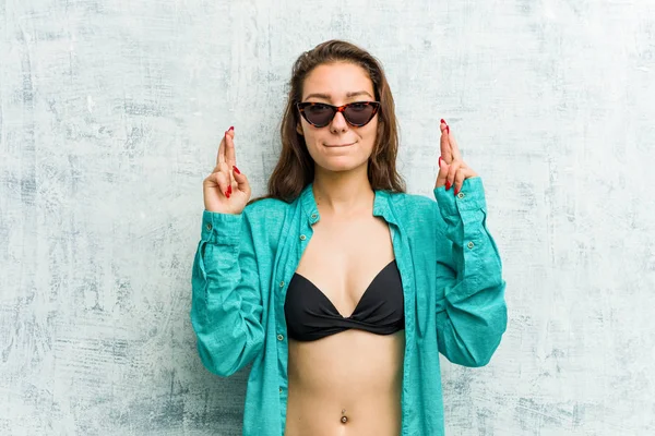Nuori Eurooppalainen Nainen Yllään Bikinit Ristikkäin Sormet Ottaa Onnea — kuvapankkivalokuva