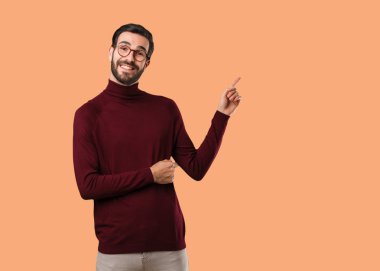 Genç, doğal bir adam parmağıyla kenarı işaret ediyor.