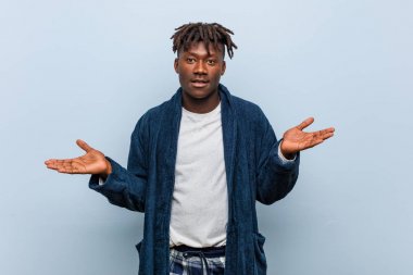 Pijama giyen Afrikalı genç bir adam hoş bir ifade sergiliyor..