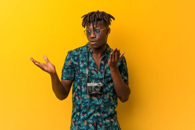 Tatil giyen genç siyah Rasta iki seçenek arasında şüpheli görünüyor..