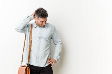 Genç yakışıklı iş adamı başının arkasına dokunuyor, düşünüyor ve bir seçim yapıyor..