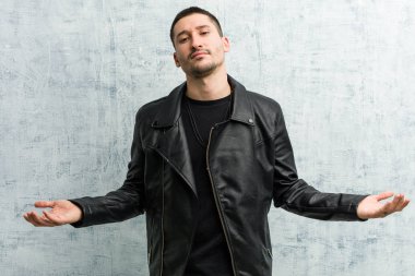 Genç rockçı bir hoş geldin ifadesi gösteriyor.