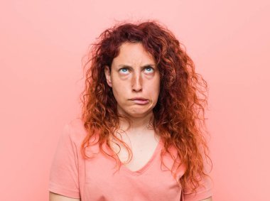 Genç, doğal ve otantik kızıl saçlı kadının kafası karışık, kuşkulu ve kendinden emin değil..