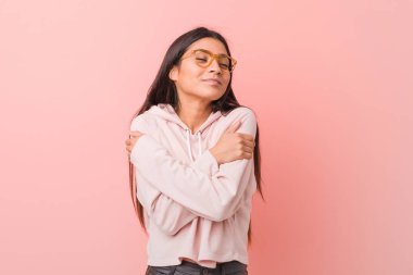 Genç, güzel bir Arap kadın spor kıyafeti giymiş. Sarılmış, kaygısız ve mutlu görünüyor..