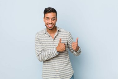 Genç yakışıklı filipinli adam, gülümseyerek ve kendinden emin her iki başparmak yükselterek.