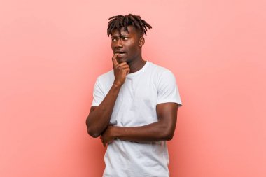 Genç Afrikalı siyah adam bir kopya uzaya bakarak bir şey hakkında rahat düşünme.