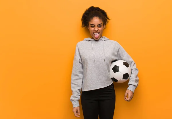 Young Fitness Black Woman Funnny Friendly Showing Tongue Holding Soccer — 스톡 사진