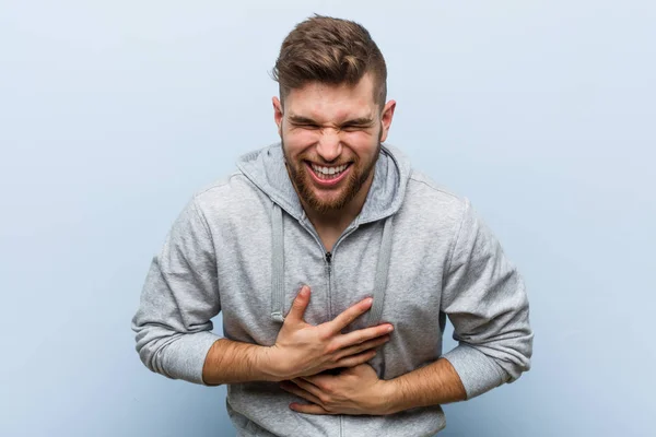 Jovem Homem Bonito Fitness Alegremente Diverte Mantendo Mãos Estômago — Fotografia de Stock