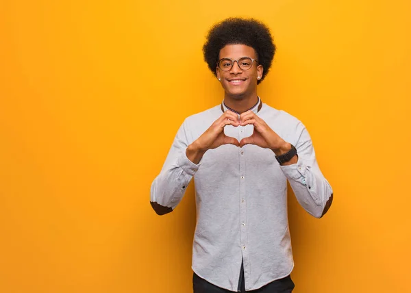 Ung Afrikansk Amerikansk Man Över Orange Vägg Gör Hjärtform Med — Stockfoto