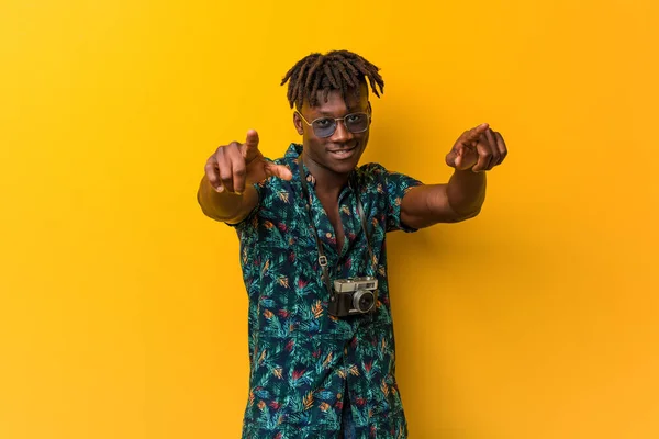 Young black rasta man wearing a vacation look cheerful smiles pointing to front.