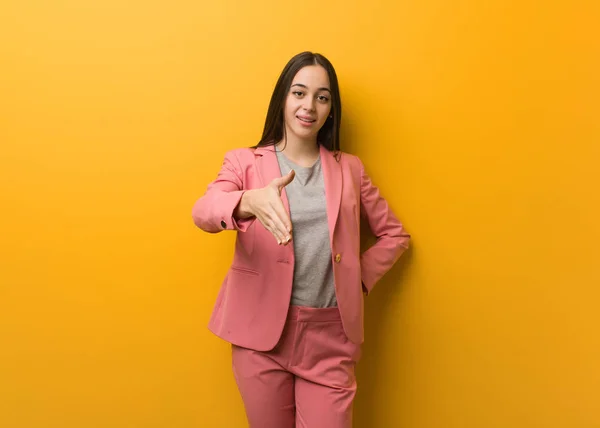 Young modern business woman reaching out to greet someone