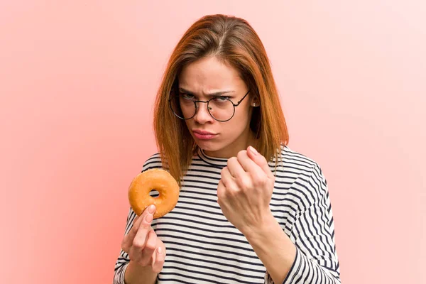 Mujer Joven Sosteniendo Donut Mostrando Puño Cámara Expresión Facial Agresiva —  Fotos de Stock