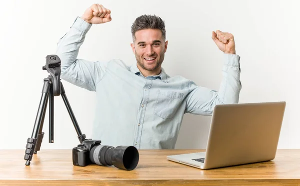 Young handsome photography teacher showing strength gesture with arms, symbol of feminine power