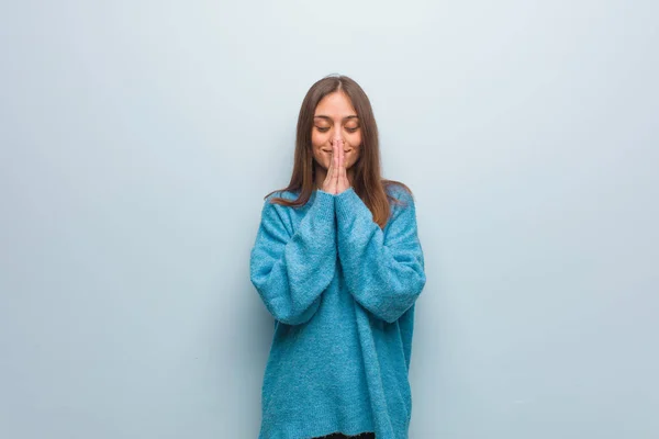 Jovem Mulher Bonita Vestindo Uma Camisola Azul Rezando Muito Feliz — Fotografia de Stock