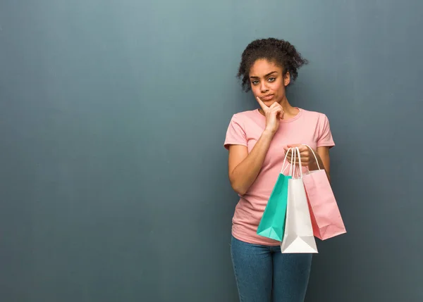 Ung Svart Kvinna Tvivlar Och Förvirrad Hon Håller Shoppingpåse — Stockfoto