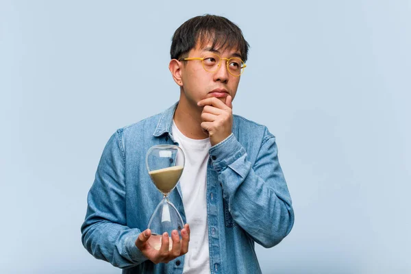 Junger Chinese Mit Sanduhr Zweifelnd Und Verwirrt — Stockfoto