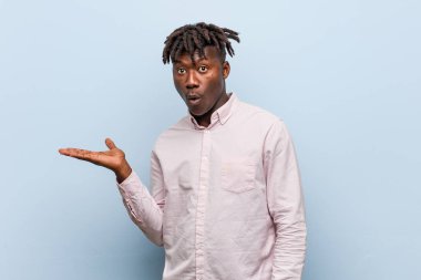 Genç iş adamı Afrikalı siyahi adam, avuç içi fotokopi alanını elinde tutmaktan etkilenmiş..