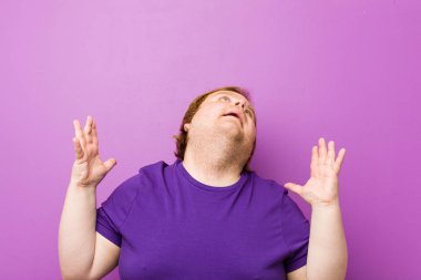 Genç otantik kızıl saçlı şişman adam gökyüzüne çığlık, yukarı bakıyor, sinirli.