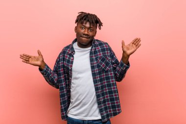 Genç Afrikalı siyahi adamın kafası karışık ve kuşkulu. Kopya alanını tutmak için ellerini kaldırıyor..