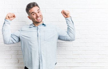 Duvara dayanmış genç yakışıklı bir adam. Güçlü hareketlerini kollarıyla gösteriyor. Kadınsı gücün sembolü.