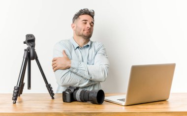 Genç yakışıklı fotoğrafçılık öğretmeni kucaklıyor, kaygısız ve mutlu gülümsüyor..