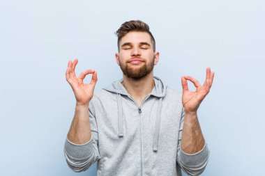 Genç yakışıklı fitness adamı yorucu bir günün ardından rahatlıyor, yoga yapıyor..