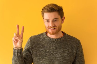 Genç kızıl saçlı adamın yüzü iki numarayı gösteriyor.