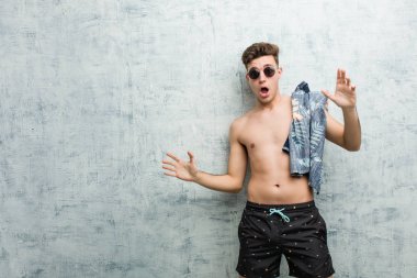 Mayo giyen genç, beyaz bir adam yaklaşan bir tehlike nedeniyle şoka uğruyor.