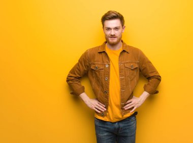 Kalçasında elleri olan genç kızıl adam.