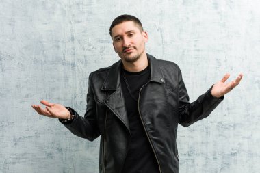 Genç rockçı sorgulama jesti için omuzlarını silkip şüphe ediyor..