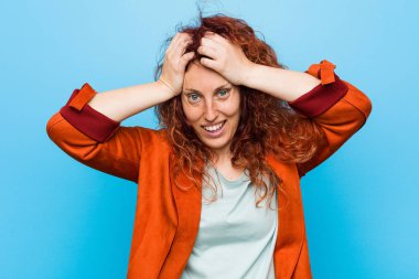 Genç kızıl saçlı zarif kadın ellerini başının üstünde tutarak neşeyle gülüyor. Mutluluk kavramı.