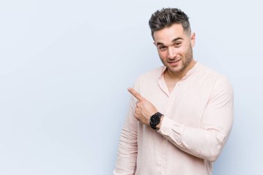Yakışıklı yakışıklı adam gülümsüyor ve boş alanda bir şeyler gösteriyor..