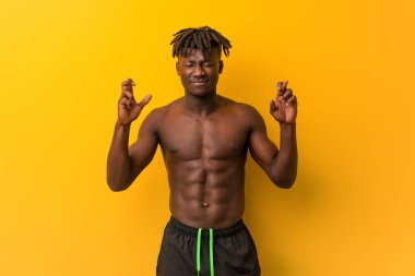 Genç siyah adam, şans dilemek için mayo giyiyor.