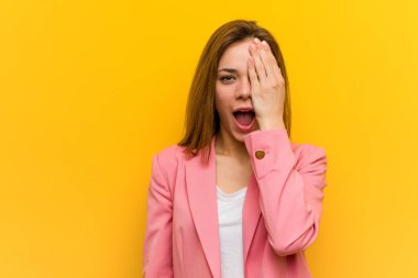 Moda işindeki genç kadın yüzünün yarısını avuç içiyle örterek eğleniyor..