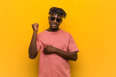 Gündelik siyah gözlüklü genç adam kafasının arkasına dokunuyor, düşünüyor ve bir seçim yapıyor..