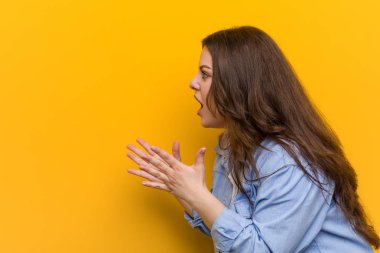 Genç kıvrımlı artı boyutu kadın yüksek sesle bağırır, gözleri açık tutar ve eller gergin.