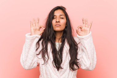 Pijama giyen genç Hintli kadın sıkı çalışma gününden sonra rahatlıyor. Yoga yapıyor..