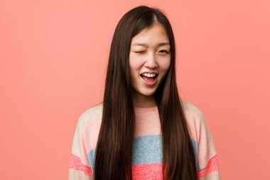 Genç havalı Çinli kadın göz kırpıyor, komik, arkadaş canlısı ve kaygısız..