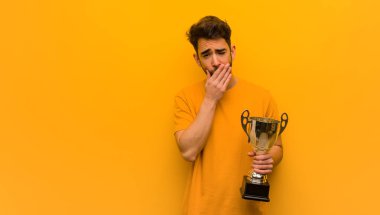 Elinde kupa tutan genç adam yorgun ve çok uykulu.