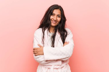 Kendine güveni olan pijama giyen genç Hintli kadın kararlılıkla kollarını kavuşturuyor..